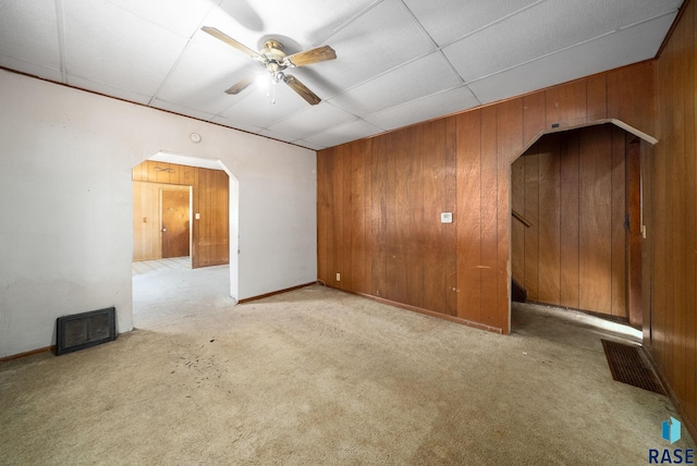 1407 N Main Ave, Sioux Falls, SD 57104 - unfurnished room with arched walkways, wood walls, ceiling fan, light carpet, and stairway