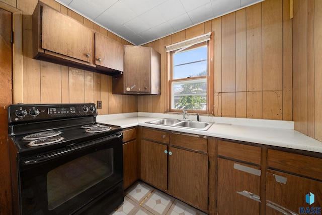 1407 N Main Ave, Sioux Falls, SD 57104 - kitchen with black electric range, wood walls, light countertops, and brown cabinetry