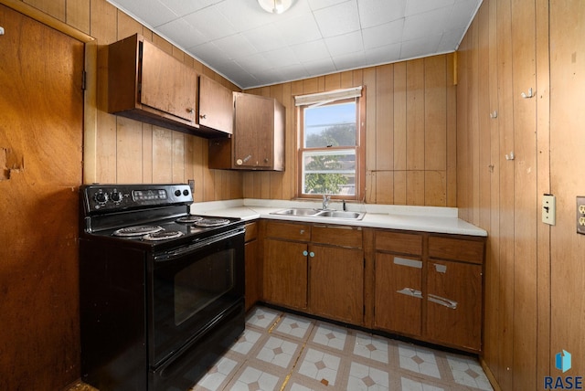 1407 N Main Ave, Sioux Falls, SD 57104 - kitchen with electric range, brown cabinetry, wood walls, and light countertops