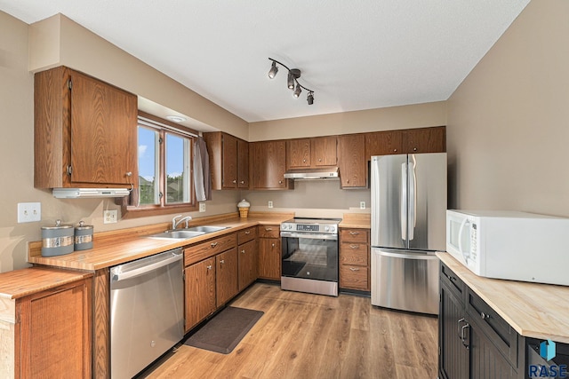 5909 W Bakker Park Dr, Sioux Falls, SD 57106 - kitchen with appliances with stainless steel finishes, under cabinet range hood, light wood-style floors, and brown cabinets