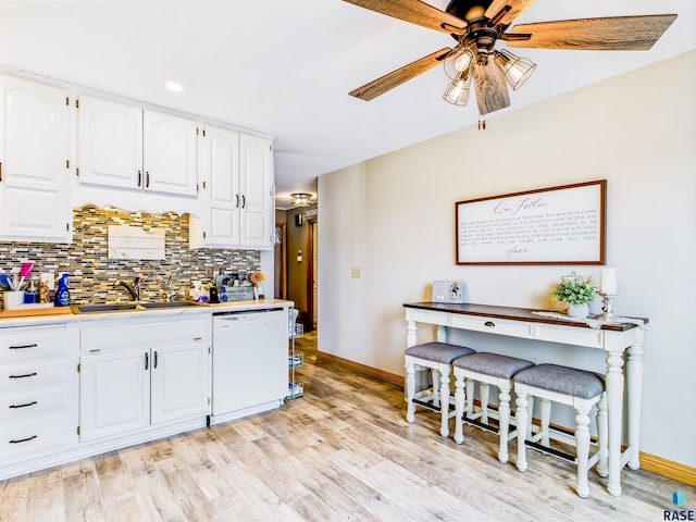 26481 487th Ave, Valley Springs, SD 57068 - kitchen with white dishwasher, ceiling fan, tasteful backsplash, light wood-style flooring, and white cabinetry