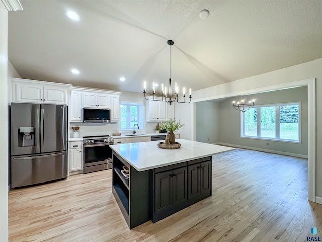 1708 E Ash Grove Cir, Sioux Falls, SD 57108 - kitchen with stainless steel appliances, a chandelier, white cabinets, light countertops, and a kitchen island