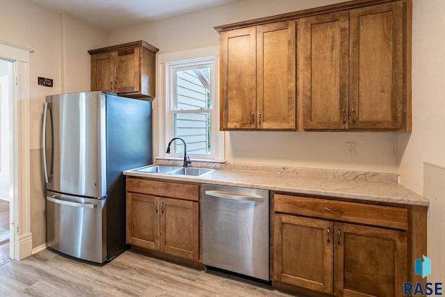 108 S Sycamore Ave, Sioux Falls, SD 57110 - kitchen featuring appliances with stainless steel finishes, light wood-style flooring, and brown cabinetry