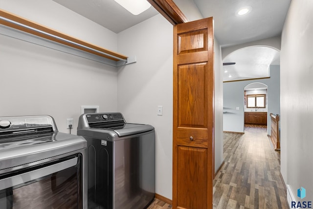 908 W 4th Ave, Lennox, SD 57039 - laundry area featuring washing machine and dryer, arched walkways, wood finished floors, and recessed lighting