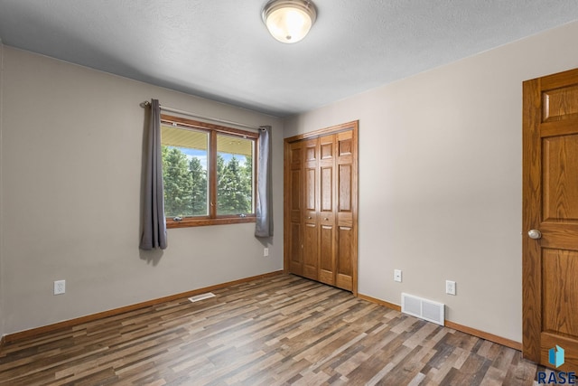 908 W 4th Ave, Lennox, SD 57039 - unfurnished bedroom featuring wood finished floors and a closet