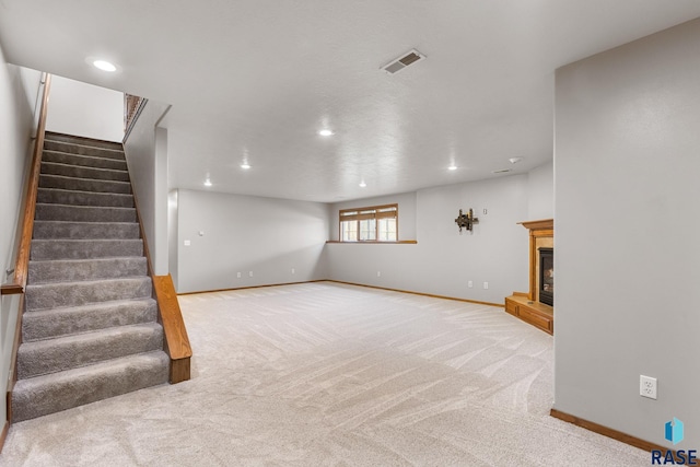 908 W 4th Ave, Lennox, SD 57039 - basement with stairs, carpet floors, a glass covered fireplace, and recessed lighting
