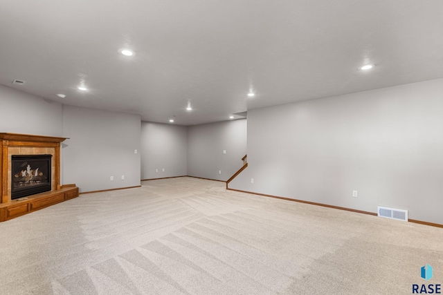 908 W 4th Ave, Lennox, SD 57039 - unfurnished living room featuring light carpet, recessed lighting, and a tiled fireplace