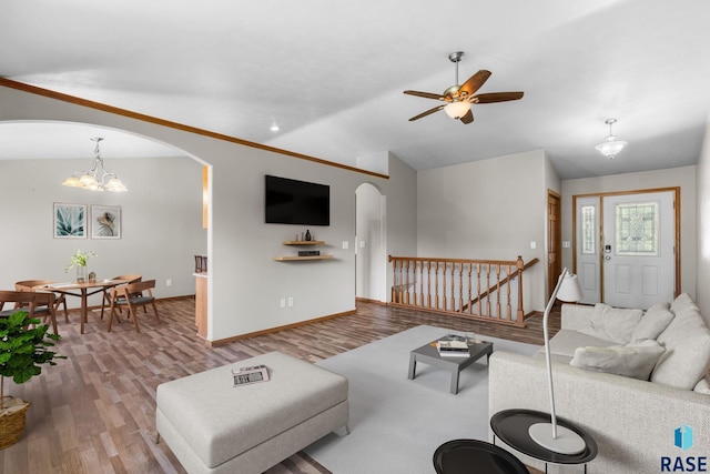 908 W 4th Ave, Lennox, SD 57039 - living room featuring arched walkways, lofted ceiling, wood finished floors, ceiling fan, and a chandelier