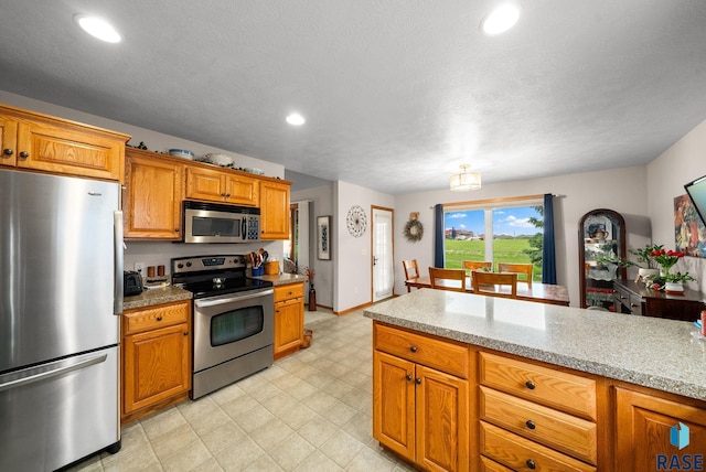 1905 S Wheatland Ct, Sioux Falls, SD 57106 - kitchen with appliances with stainless steel finishes, brown cabinetry, recessed lighting, and light flooring