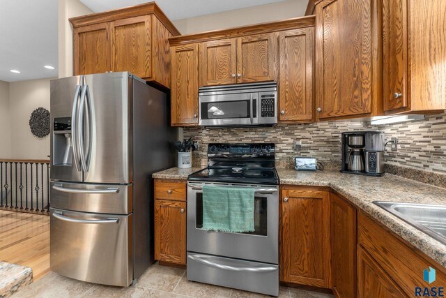 2213 S Purdue Ave, Sioux Falls, SD 57106 - kitchen featuring stainless steel appliances, brown cabinets, tasteful backsplash, and recessed lighting