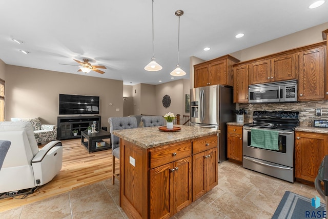 2213 S Purdue Ave, Sioux Falls, SD 57106 - kitchen featuring appliances with stainless steel finishes, brown cabinets, open floor plan, tasteful backsplash, and recessed lighting