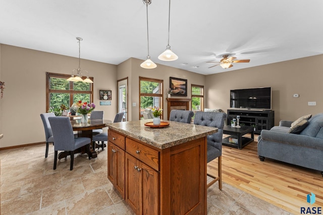 2213 S Purdue Ave, Sioux Falls, SD 57106 - kitchen featuring brown cabinetry, a kitchen island, healthy amount of natural light, and pendant lighting