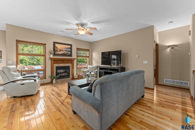 2213 S Purdue Ave, Sioux Falls, SD 57106 - living area featuring a tiled fireplace, light wood finished floors, a ceiling fan, and healthy amount of natural light