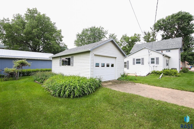 228 N Broadway St, Canton, SD 57013 - view of front of house with a detached garage, driveway, an outbuilding, and a front lawn