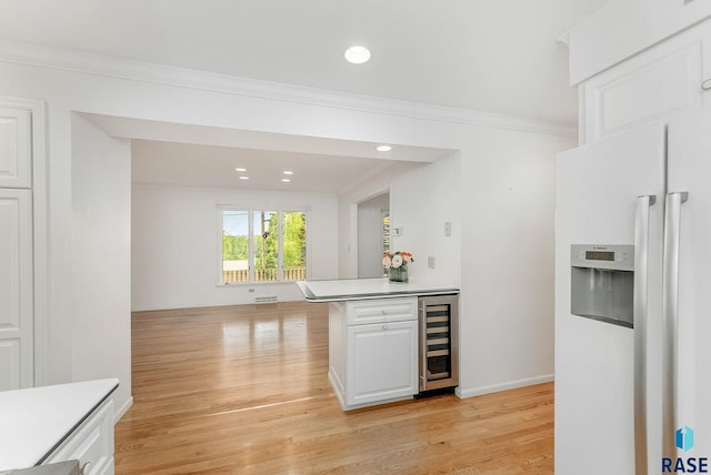 915 E Ridge Rd, Sioux Falls, SD 57105 - kitchen featuring white fridge with ice dispenser, wine cooler, white cabinets, light wood finished floors, and crown molding