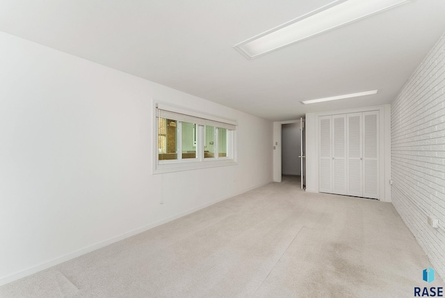 915 E Ridge Rd, Sioux Falls, SD 57105 - unfurnished bedroom with light carpet, brick wall, and a closet
