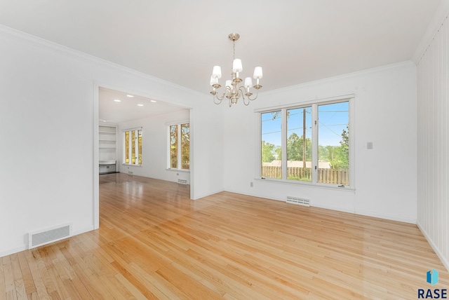 915 E Ridge Rd, Sioux Falls, SD 57105 - spare room featuring a chandelier, wood finished floors, and ornamental molding