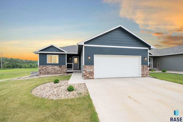 7513 E 49th St, Sioux Falls, SD 57110 - view of front of property featuring a garage, stone siding, a front yard, and concrete driveway