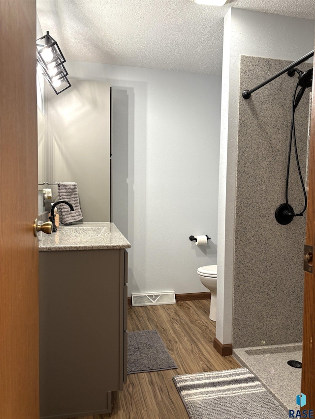 421 E 2nd St, Miller, SD 57362 - full bathroom featuring a stall shower, vanity, wood finished floors, and a textured ceiling