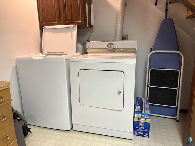 421 E 2nd St, Miller, SD 57362 - laundry area featuring light flooring, cabinet space, and washing machine and clothes dryer