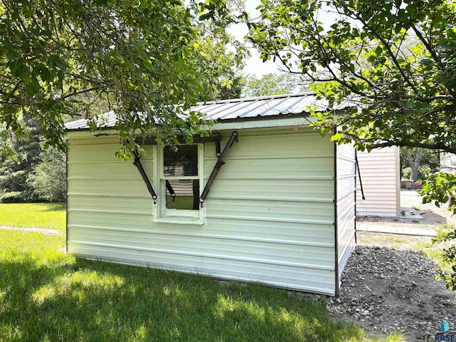 421 E 2nd St, Miller, SD 57362 - view of home's exterior with an outdoor structure, a metal roof, and a lawn