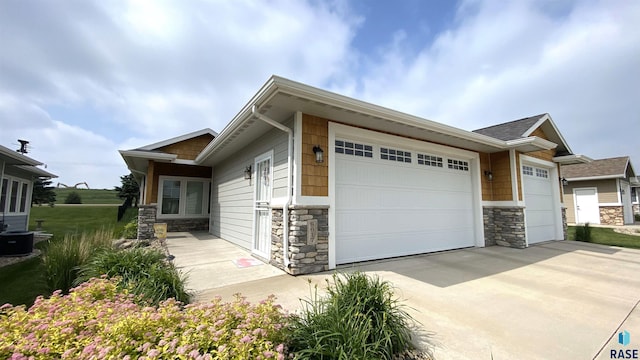 8617 W Bryggen Ct, Sioux Falls, SD 57107 - view of side of property with stone siding, an attached garage, and driveway