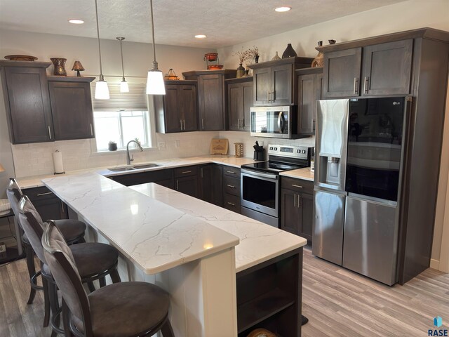8617 W Bryggen Ct, Sioux Falls, SD 57107 - kitchen with appliances with stainless steel finishes, dark brown cabinetry, open shelves, tasteful backsplash, and recessed lighting