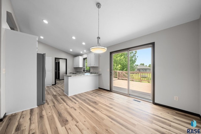 301 W 6th St, Crooks, SD 57020 - kitchen with a peninsula, light wood-style floors, recessed lighting, freestanding refrigerator, and white cabinetry