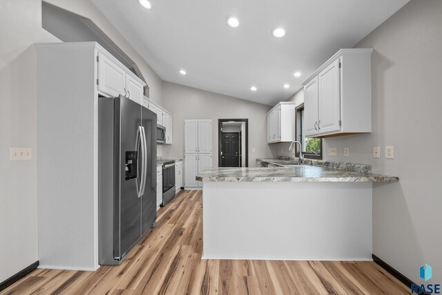 301 W 6th St, Crooks, SD 57020 - kitchen with stainless steel appliances, a peninsula, light wood-style flooring, white cabinets, and vaulted ceiling