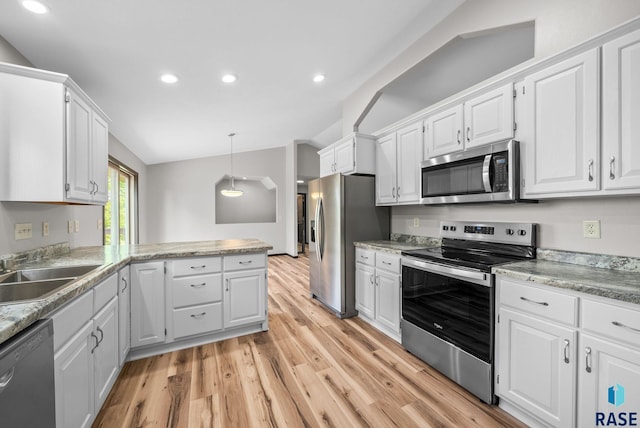 301 W 6th St, Crooks, SD 57020 - kitchen with stainless steel appliances, light wood-type flooring, lofted ceiling, recessed lighting, and white cabinets