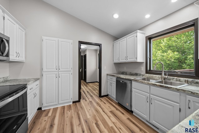 301 W 6th St, Crooks, SD 57020 - kitchen with stainless steel appliances, vaulted ceiling, white cabinetry, light wood finished floors, and recessed lighting