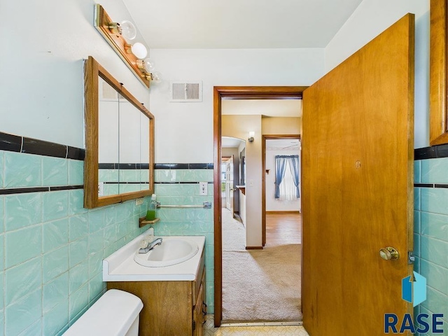1721 W 11th St, Sioux Falls, SD 57104 - bathroom with tile walls, vanity, and a wainscoted wall