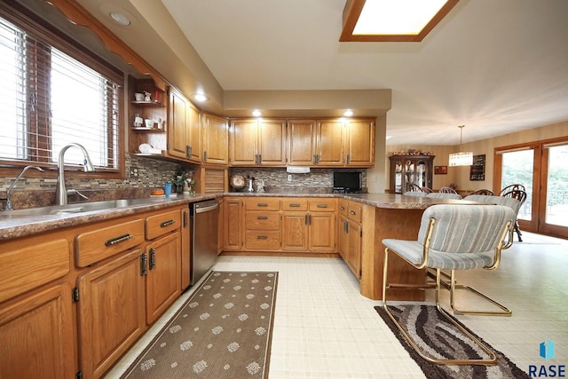 429 S Elm St, Lennox, SD 57039 - kitchen featuring dishwasher, light floors, a peninsula, backsplash, and brown cabinets