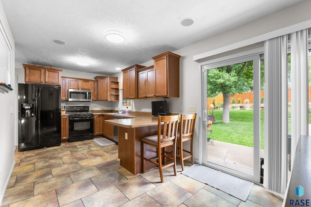 2424 S Main Ave, Sioux Falls, SD 57105 - kitchen with black appliances, open shelves, brown cabinetry, a peninsula, and light countertops