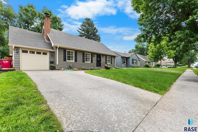 2424 S Main Ave, Sioux Falls, SD 57105 - view of front facade with an attached garage, driveway, a front yard, a chimney, and a shingled roof