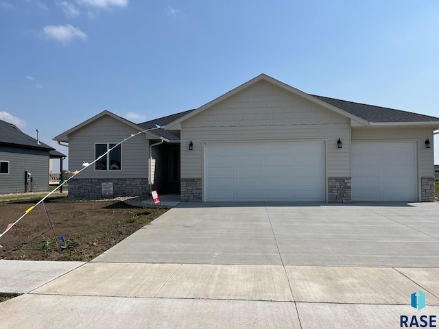 6705 37th St, Sioux Falls, SD 57110 - ranch-style house with a garage, concrete driveway, and stone siding