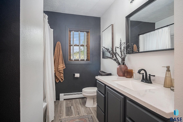 300 W 3rd St, Tea, SD 57064 - full bathroom with a baseboard heating unit, wood finished floors, and vanity