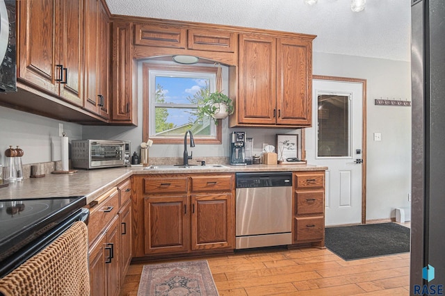 300 W 3rd St, Tea, SD 57064 - kitchen with stainless steel dishwasher, light wood-style floors, brown cabinetry, light countertops, and a textured ceiling