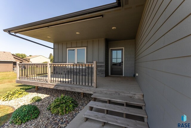 116 Lynx St, Valley Springs, SD 57068 - property entrance featuring a wooden deck and board and batten siding