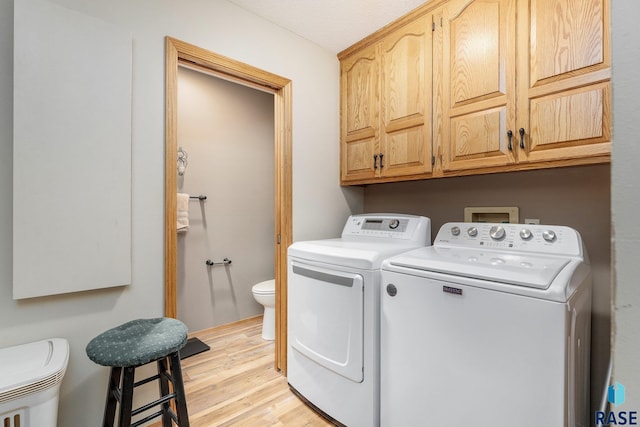 4808 S Shields Ave, Sioux Falls, SD 57103 - laundry room with washing machine and clothes dryer, light wood-style flooring, and cabinet space
