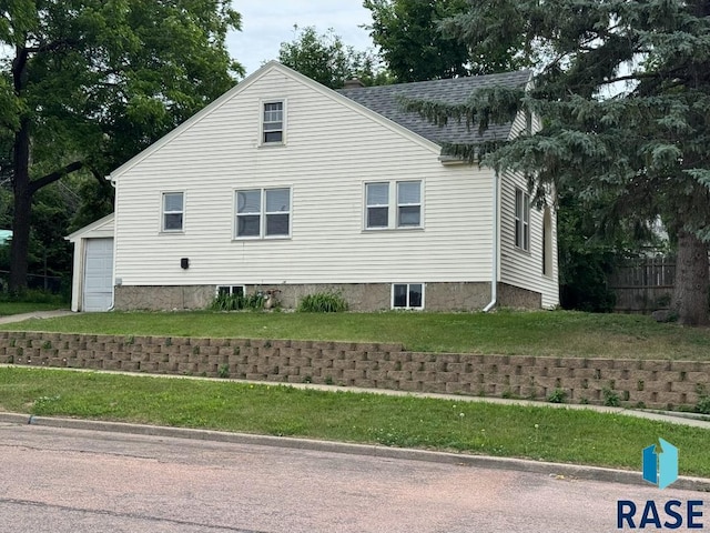 1330 W 14th St, Sioux Falls, SD 57104 - view of side of home with a shingled roof, a yard, and a garage