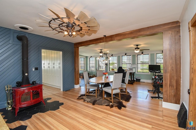 47138 293rd St, Beresford, SD 57004 - dining area featuring a wood stove, light wood-style floors, wooden walls, and ceiling fan