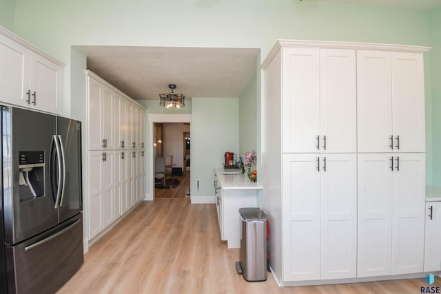 47138 293rd St, Beresford, SD 57004 - kitchen with stainless steel fridge, light countertops, light wood-type flooring, and white cabinetry
