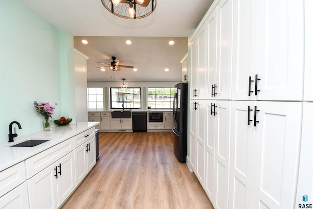 47138 293rd St, Beresford, SD 57004 - kitchen featuring black appliances, recessed lighting, light wood finished floors, and white cabinetry