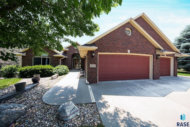 6811 E Split Rock Cir, Sioux Falls, SD 57110 - view of front facade featuring a garage, brick siding, and concrete driveway