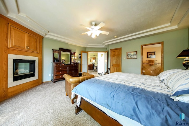 6811 E Split Rock Cir, Sioux Falls, SD 57110 - bedroom featuring a tray ceiling, light carpet, a large fireplace, a ceiling fan, and connected bathroom