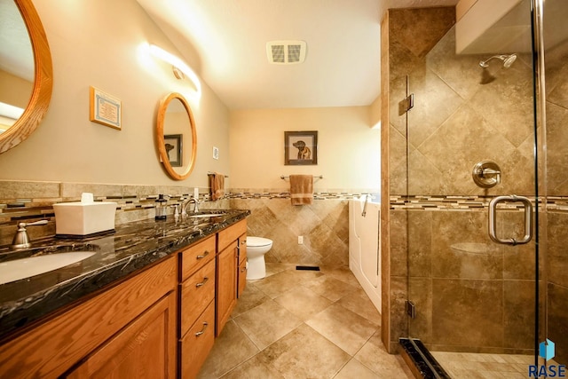 6811 E Split Rock Cir, Sioux Falls, SD 57110 - full bathroom featuring double vanity, tile walls, a shower stall, tile patterned floors, and wainscoting