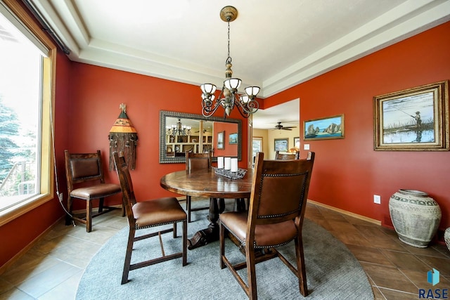 6811 E Split Rock Cir, Sioux Falls, SD 57110 - tiled dining room featuring a chandelier, a tray ceiling, and ceiling fan