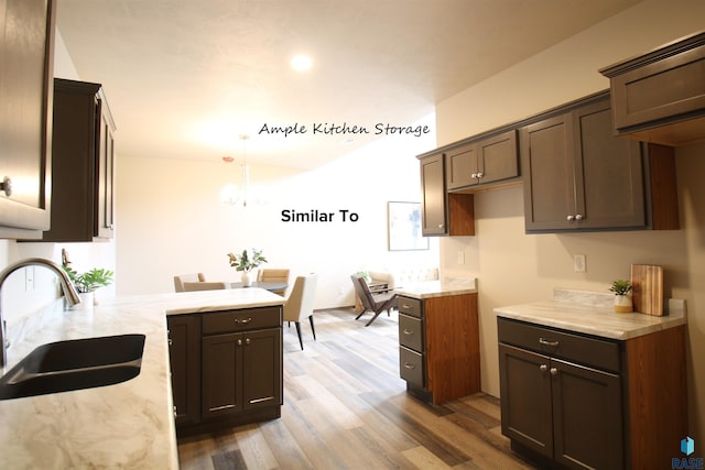 7713 S Townsley Ave Unit 4, Sioux Falls, SD 57108 - kitchen with wood finished floors, light stone counters, a peninsula, pendant lighting, and a chandelier