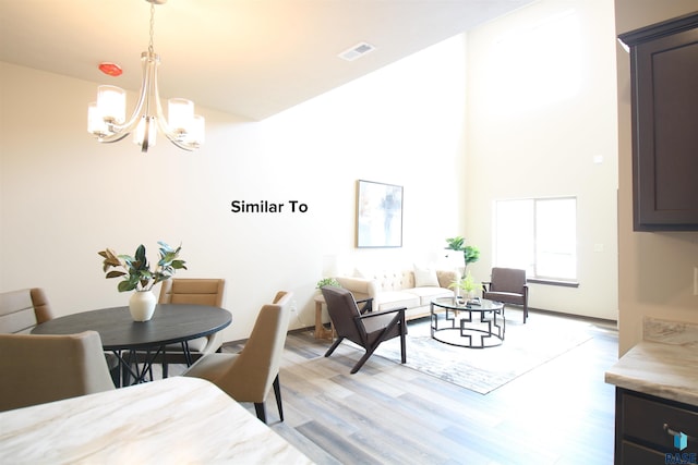7713 S Townsley Ave Unit 4, Sioux Falls, SD 57108 - dining area with light wood-style floors, a chandelier, and a high ceiling